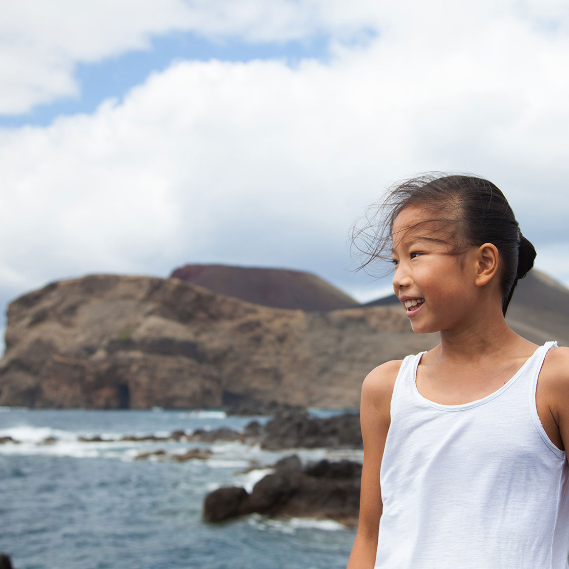 Girl with Capelinhos Volcano on the Background. Faial half day includes the main attractions.